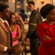 Shanice (Brittany Adebumola) wears a fairly modern red suit as a number of 4400 abductees wear different eras of clothing around her.